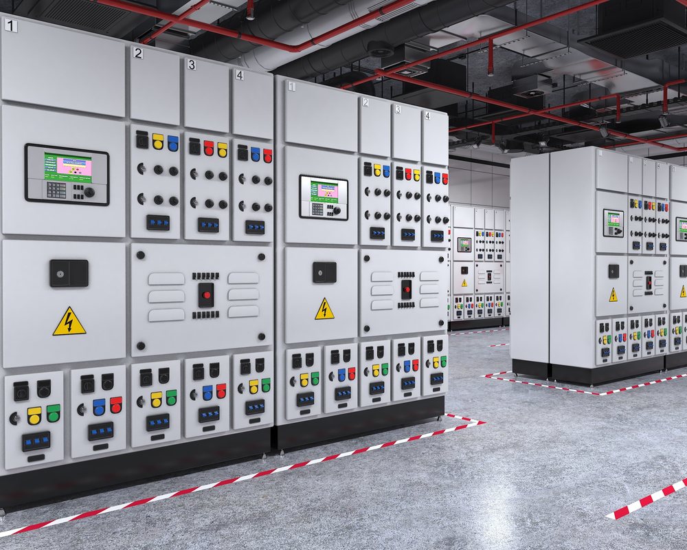 Power systems engineer reviewing substation control room SCADA data